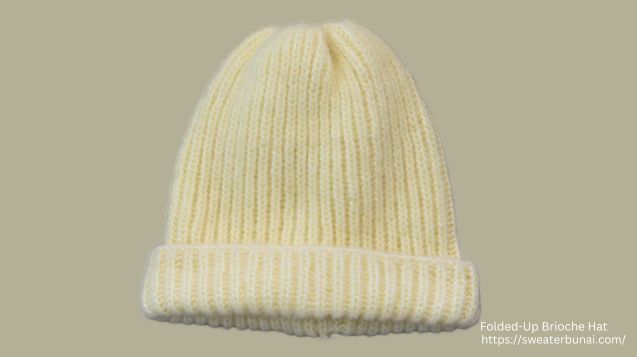 Cream-colored hand-knit Brioche Stitch Hat, styled in a folded-up design.